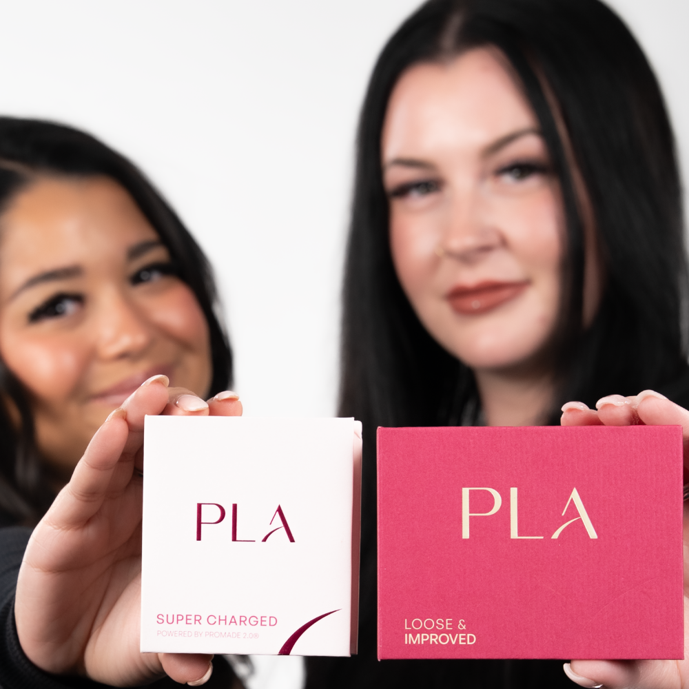 Photo of two women holding the PLA Super Charged and Loose and Improved boxes
