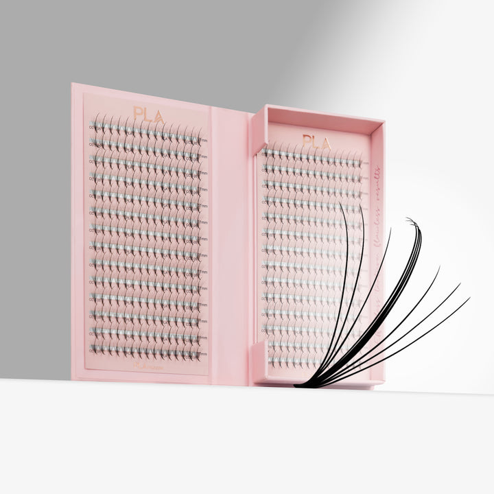 Pink lash tray packaging with rows of eyelash promades. Close up of wispy promade on the right side of open tray. All on a clean white and gray studio background.