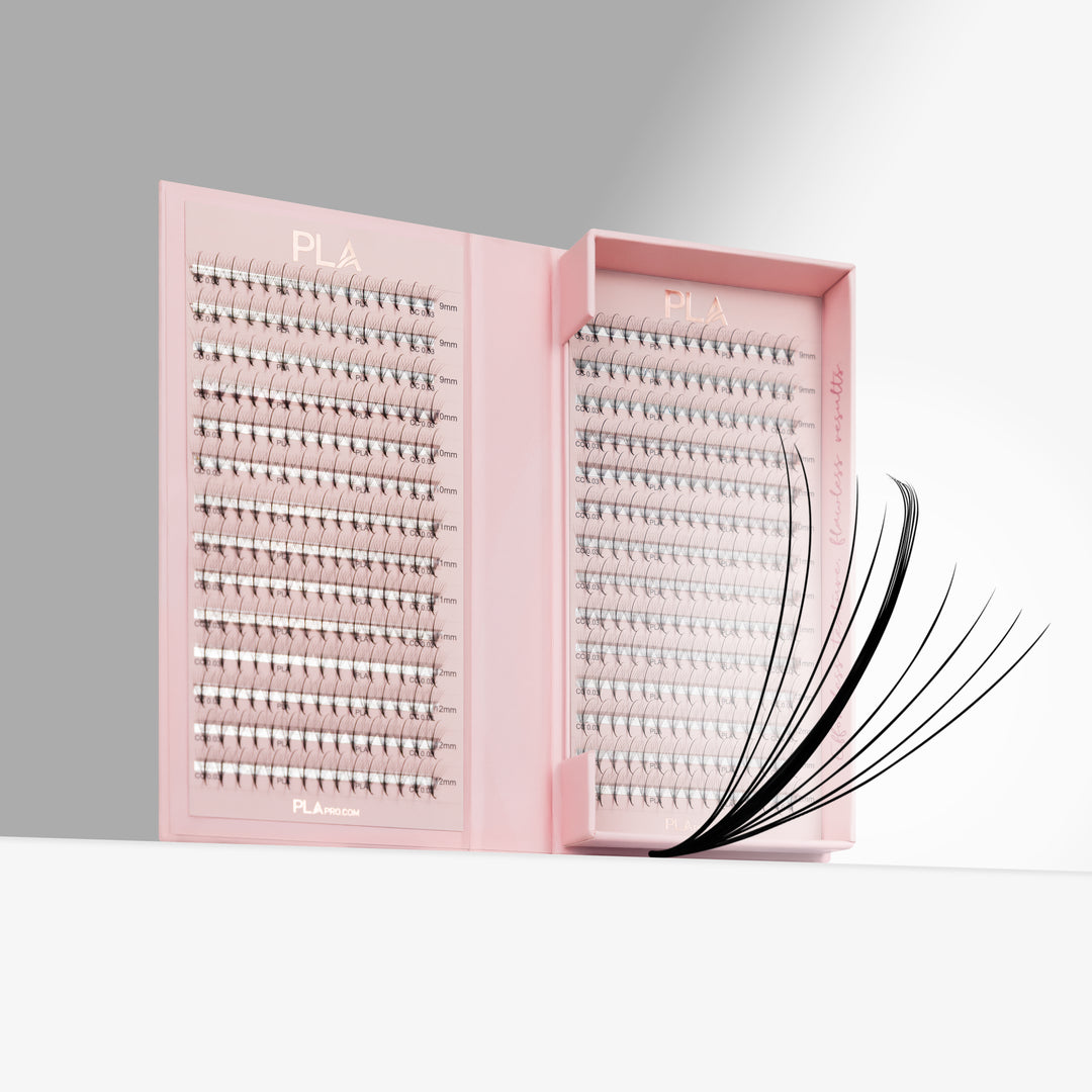 Pink PLA eyelash extension tray shown open, with rows of lashes inside and a promade fan from the front, on a clean white and gray studio background.