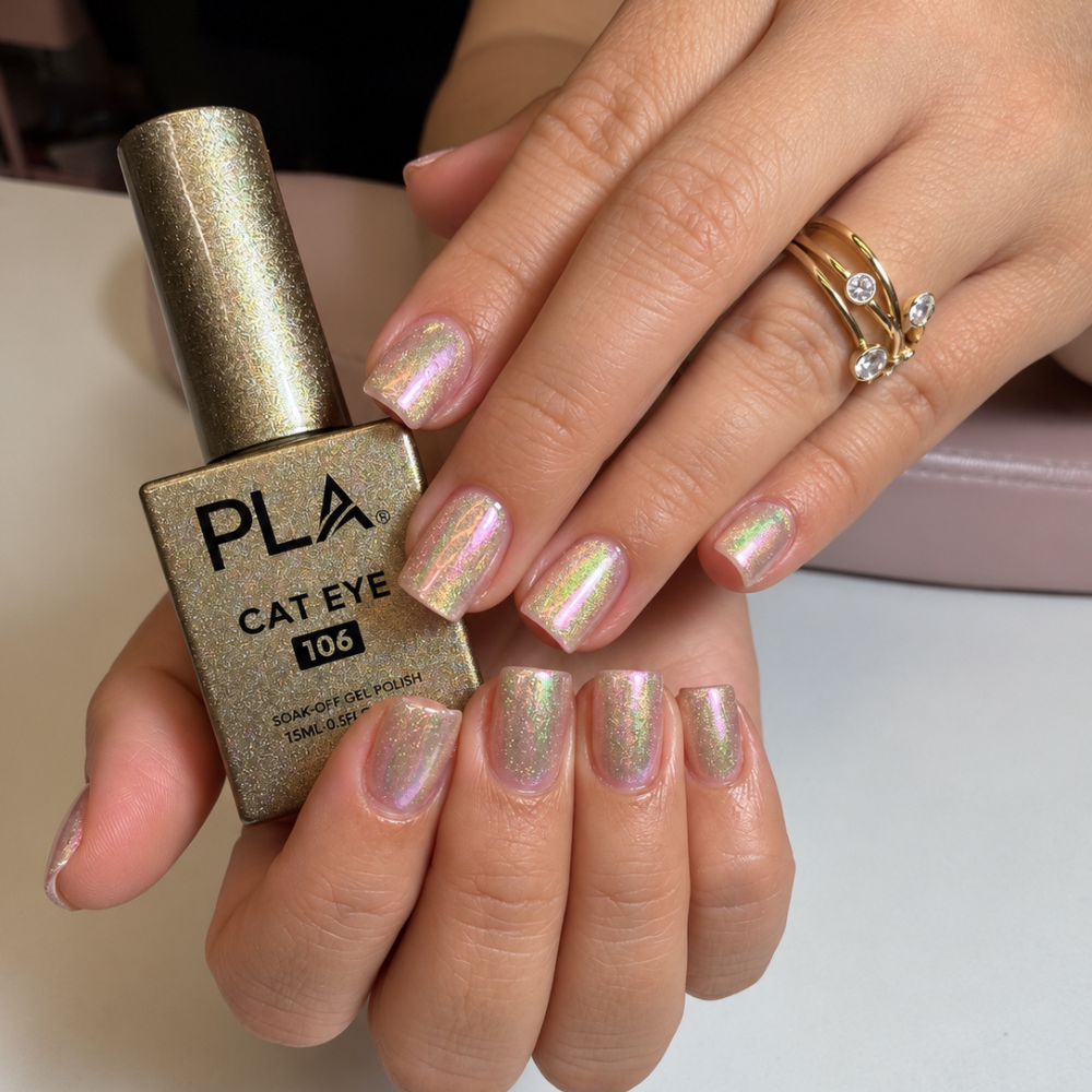 Short square nails with an iridescent pink and gold chrome finish holding a bottle of PLA Cat Eye Gel Polish in shade 106.
