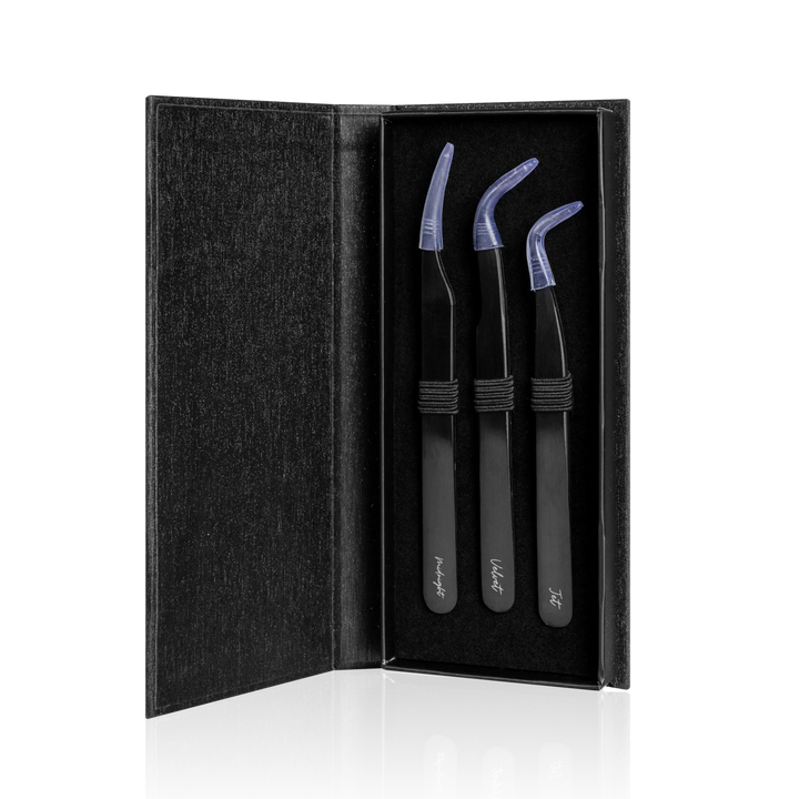 Set of three black tweezers with covers in a black case on a white background