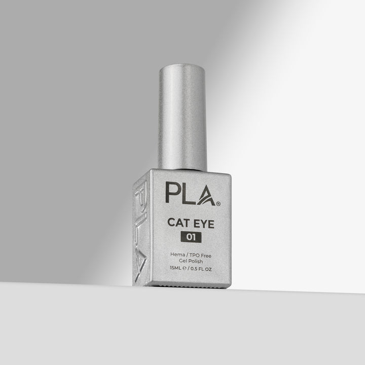 A bottle of PLA Cat Eye 01 gel nail polish with a silver cap and a square silver bottle, standing on a light gray surface against a gray background.
