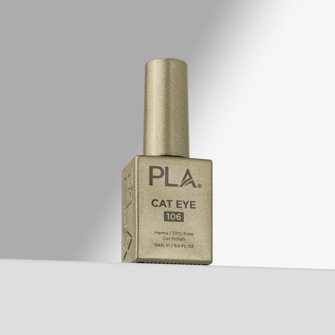 A bottle of PLA Cat Eye 106 gel nail polish in a gold shade, standing upright on a light gray surface against a gradient gray background.
