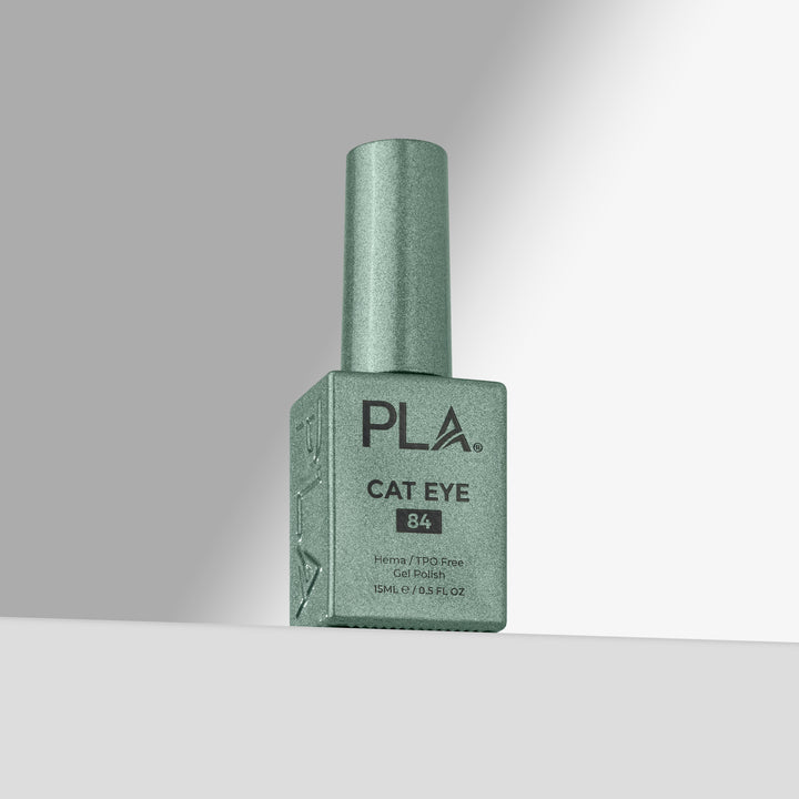 A bottle of PLA Cat Eye gel nail polish in shade 84, featuring a shimmering green cap and a matching square bottle with black text, set against a clean gray studio background.