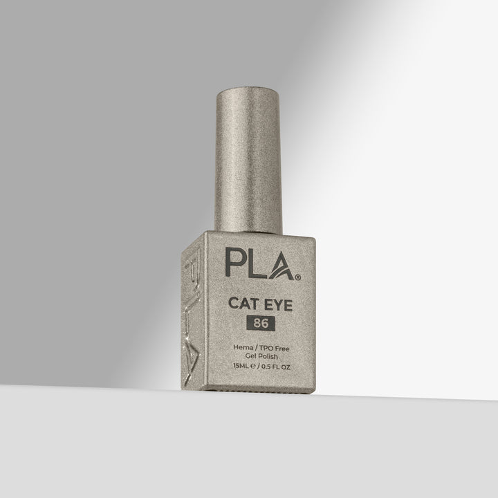 A bottle of PLA Cat Eye nail polish in shade 86, featuring a  silver cap and a silver-gray bottle with black lettering, set against a clean gray gradient background.