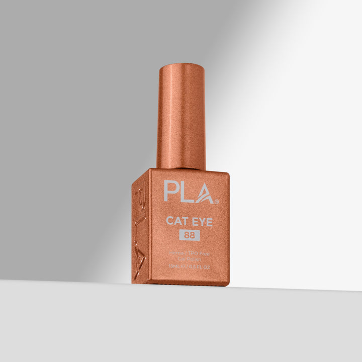 A bottle of PLA Cat Eye nail polish in shade 88, featuring a copper-rose shimmer finish, set against a clean gray studio background 