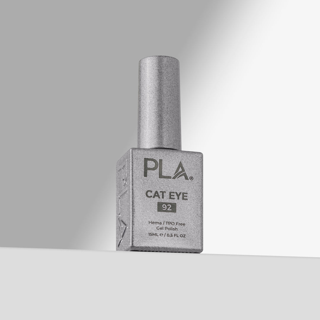 A bottle of PLA Cat Eye nail polish in shade 92, featuring a silver cap and a silver-gray rectangular bottle, set against a clean gray studio background 