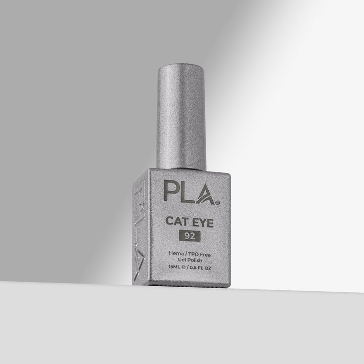 A bottle of PLA Cat Eye nail polish in shade 92, featuring a silver cap and a silver-gray rectangular bottle, set against a clean gray studio background 