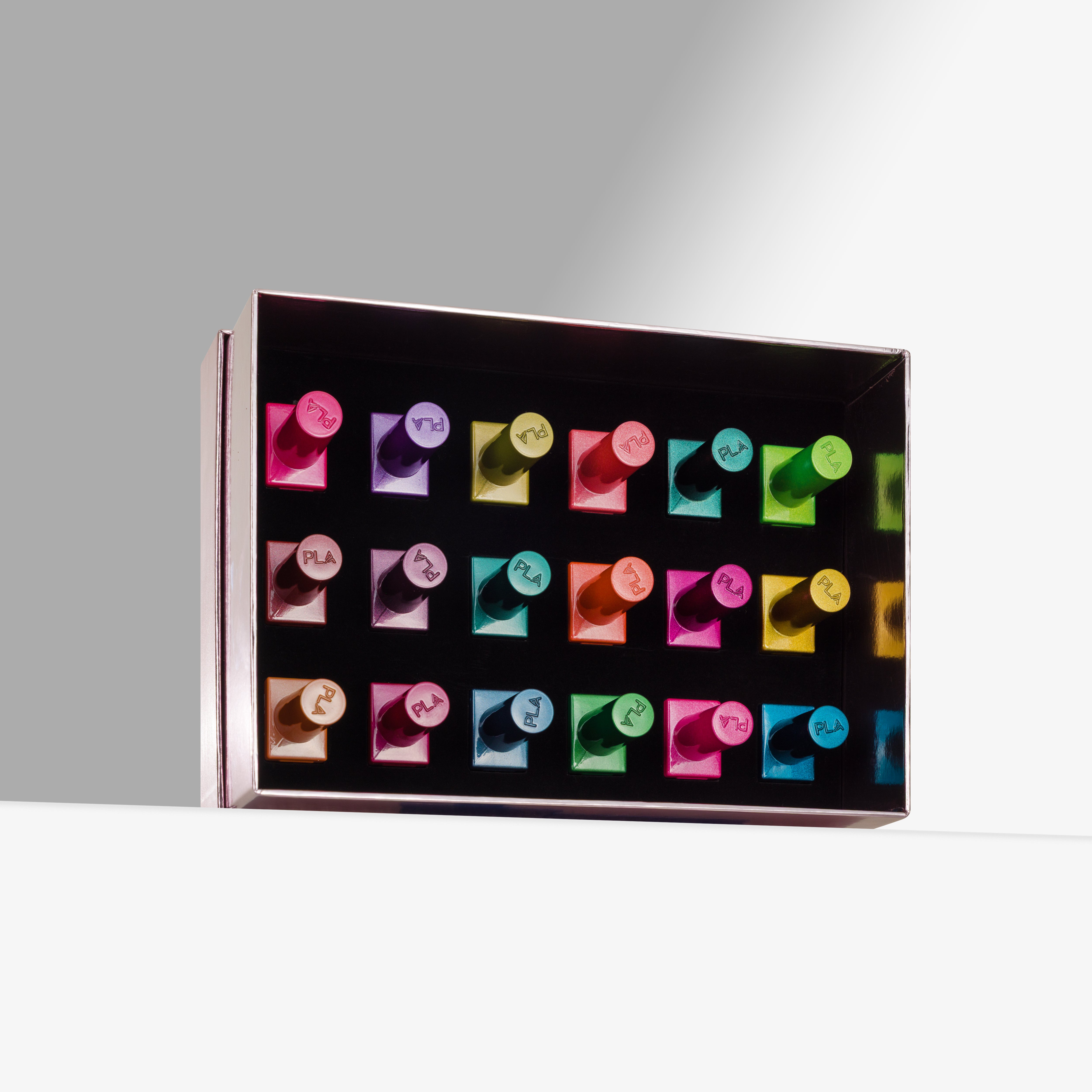 A rectangular pink box containing multiple colorful cat eye gel nail polishes arranged in rows, photographed on a clean white surface against a light gray background.