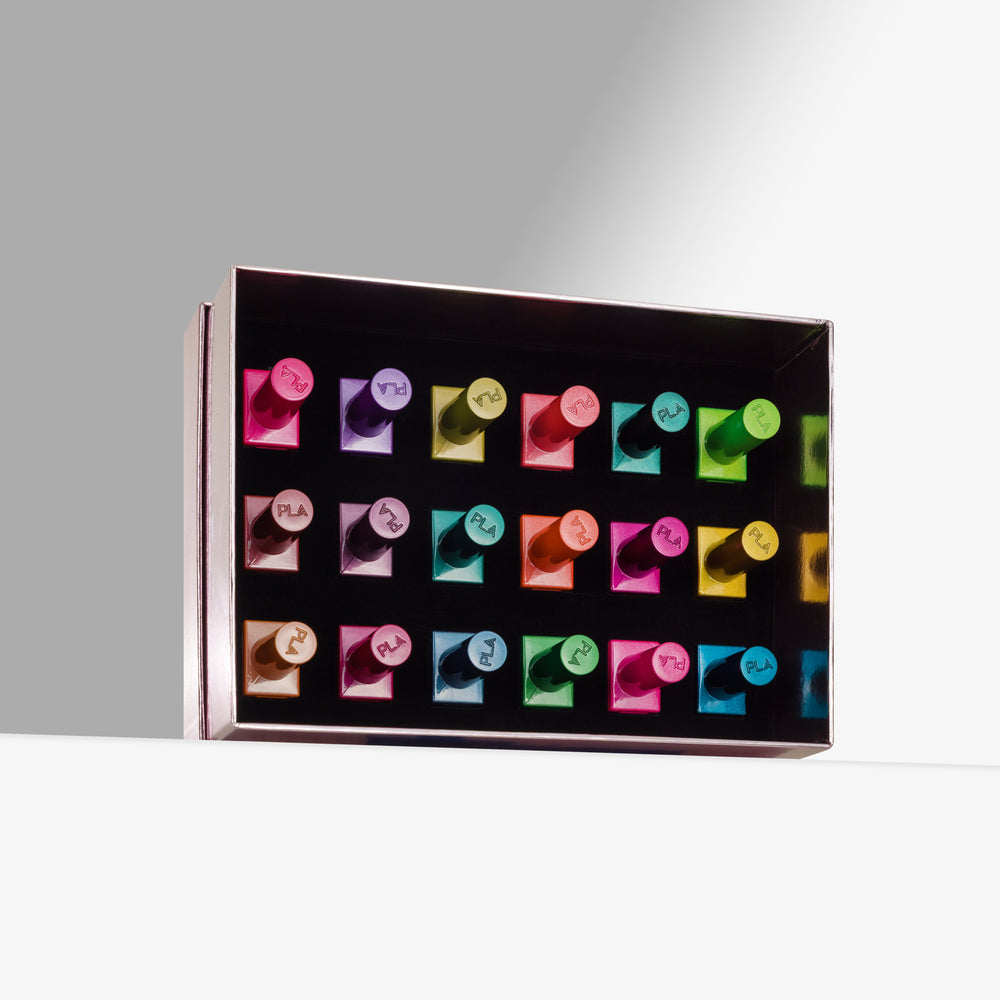 A rectangular pink box containing multiple colorful cat eye gel nail polishes arranged in rows, photographed on a clean white surface against a light gray background.