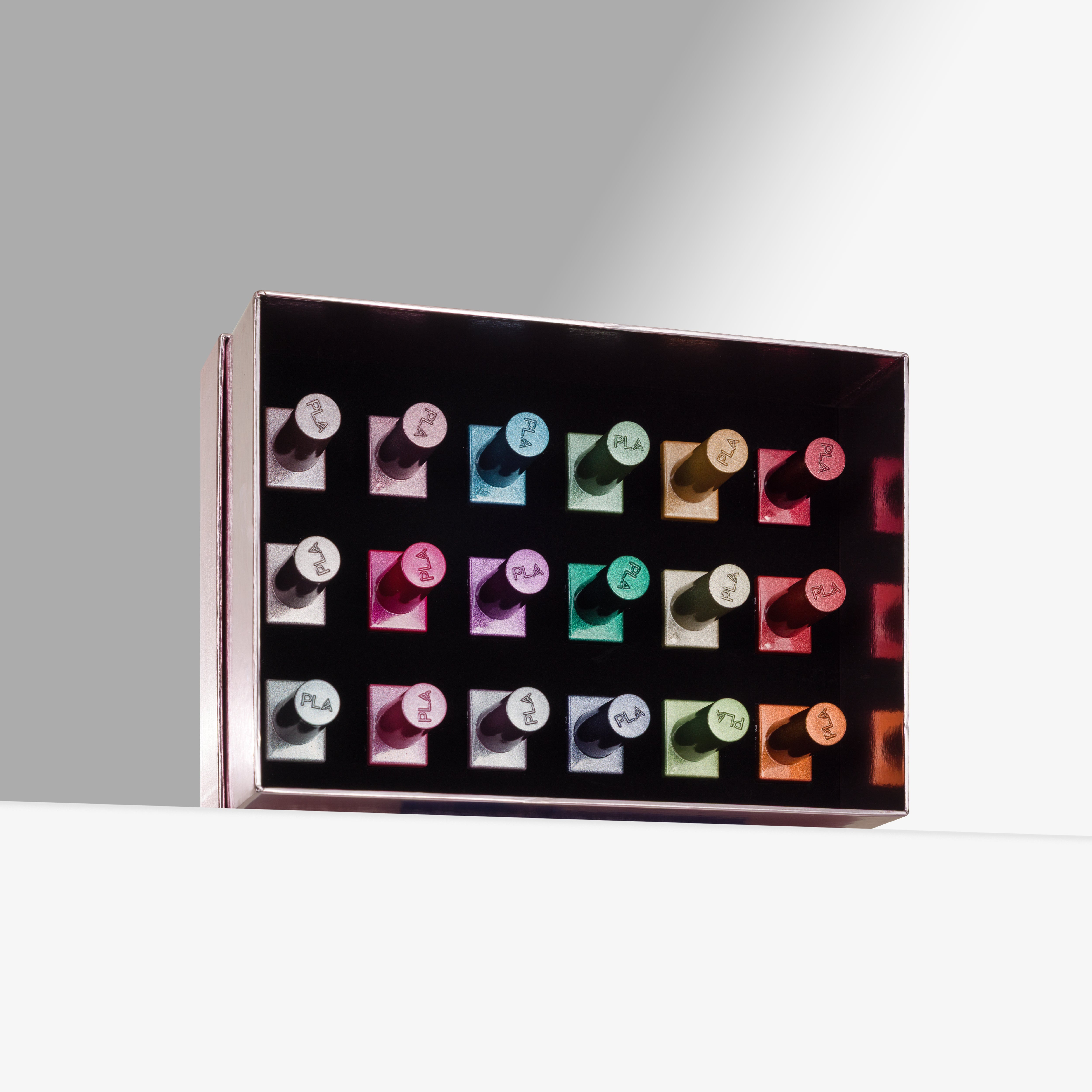 A rectangular pink box containing multiple cat eye gel nail polishes arranged in a grid, photographed on a clean white surface against a light gray background.